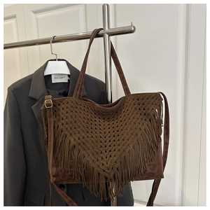 Detail of brown crochet tote bag with V-shaped weave, long tassels and leather straps