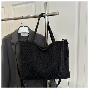 Detail of black fringe tote bag with leopard texture and boho hand-woven tassel accents