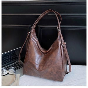 Detail of dark brown faux leather tote bag with large capacity and fine stitching texture