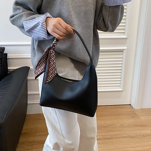 Sac sous le bras noir minimaliste en forme de croissant avec foulard en soie sur l'anse