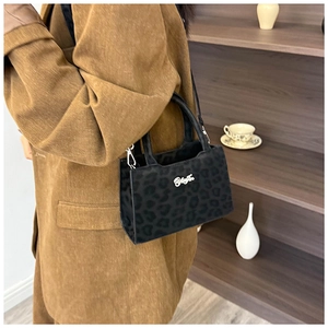 Détail du sac bandoulière léopard noir avec logo argenté et doubles poignées