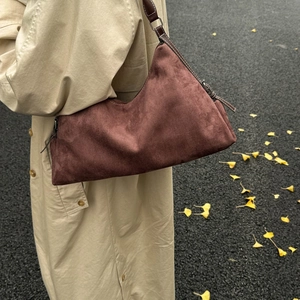 Detailed texture of dark brown suede shoulder bag paired with an autumn beige trench coat