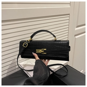 Close-up of black crocodile texture leather bag with elegant gold twist lock and handle