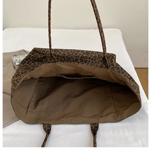 Interior view of the leopard print tote bag showing dark lining and the inner pocket detail