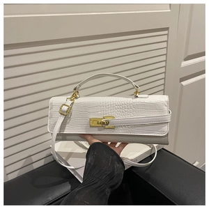Detail shot of white crocodile pattern faux leather handbag with golden metal lock buckle