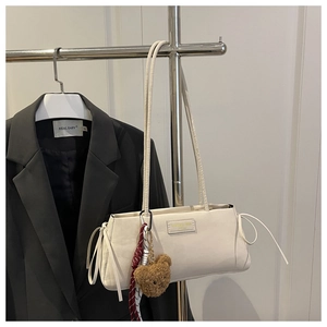 Dettaglio della borsa sottobraccio in pelle bianca con coulisse e ciondolo a forma di orso