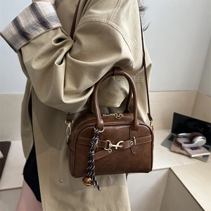 Vintage brown leather Boston bag with gold horsebit detail and woven charm for women