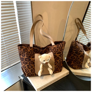 Detail of leopard print tote bag featuring a cute plush bear in the front pocket