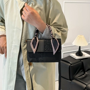 Women's black shoulder bag with glitter texture and checkered scarf on top handle