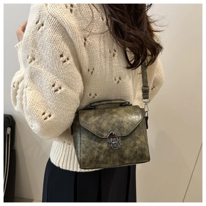 Détail du petit sac bandoulière vintage vert olive avec fermoir métal et texture cuir