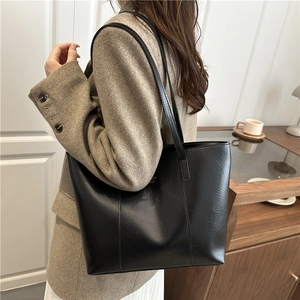 Fashionable black faux leather tote bag for women with minimalist golden logo detail