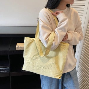 Minimalist bright yellow canvas tote bag with heart embroidery and long shoulder straps