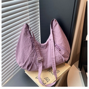 Detail view of purple nylon crescent bag featuring wrinkled texture and adjustable strap