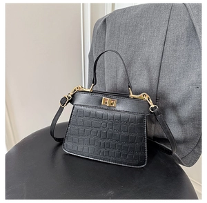 Dettaglio borsa a mano trapezoidale nera coccodrillo con chiusura a scatto dorata
