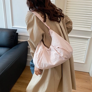 Pink large capacity nylon shoulder bag for women styled with a casual trench coat