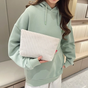 Détail du sac à main en velours côtelé beige avec étiquette mode tenu par un mannequin