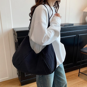 Minimalist large black hobo shoulder bag with textured fabric for women in casual setting