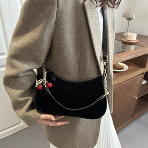 Fashionable black matte suede underarm bag with cherry pendant and metal chain detail