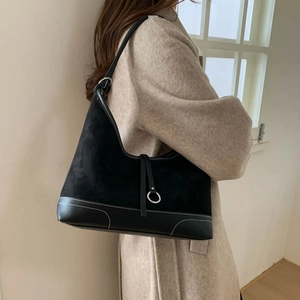 Black matte hobo bag with contrast white stitching and metallic ring detail on shoulder strap