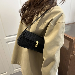 Chic black leopard print underarm bag with gold metal clasp on a khaki trench coat
