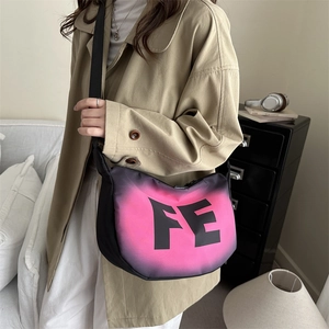 Black nylon crossbody saddle bag featuring a pink gradient logo and wide shoulder strap