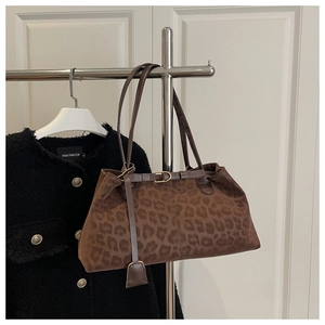 Detail of leopard print tote bag with metal buckle and long leather shoulder strap