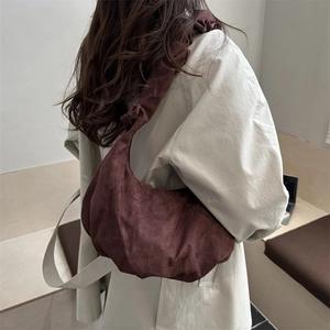 Borsa hobo minimalista in pelle scamosciata marrone scuro a mezzaluna indossata da modella