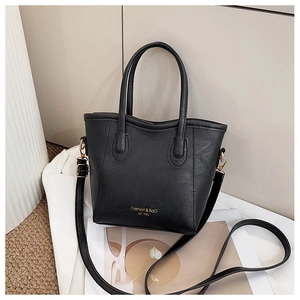 Close-up of black litchi pattern leather handbag with gold logo and thin shoulder strap