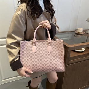 Sac fourre-tout rose vintage avec motifs M marron et anses en cuir, style urbain chic