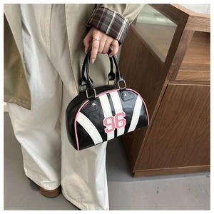 Dettaglio borsa Boston con ricamo 96 rosa, strisce bianche e rivetti a stella argento