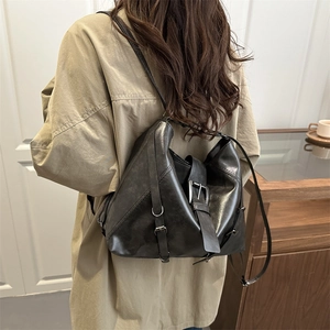 Minimalist black faux leather tote bag with silver buckle straps and vintage texture