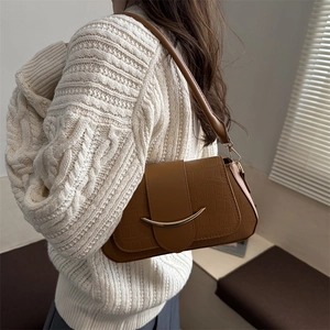 Sacoche marron texture crocodile avec boucle dorée en croissant portée par mannequin