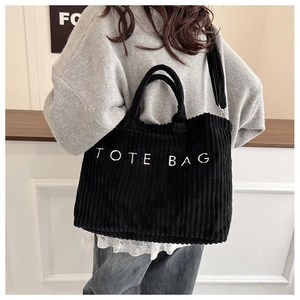 Détail du sac cabas en velours côtelé noir avec broderie TOTE BAG et bandoulière