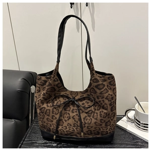 Détail du sac cabas imprimé léopard avec nœud noir et poignées en cuir élégantes