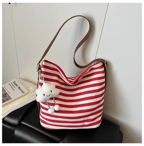 Detail of red striped canvas hobo tote featuring leather strap and plush cloud charm