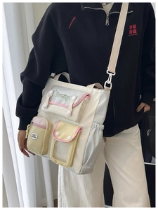 Detail of a preppy color-block bucket bag with multiple pockets and wide strap