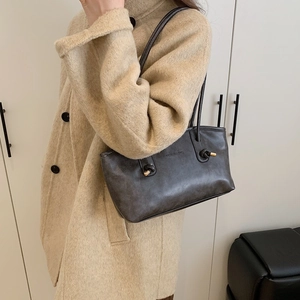Fashionable dark grey leather tote bag with gold metal accents and shoulder strap