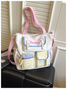 Detail of nylon shoulder bag featuring multiple pockets and clear window slot