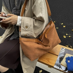 Caramel suede tote bag with leather straps and detachable shoulder strap in outdoor autumn setting