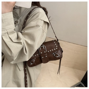 Detail of dark brown leather handbag with silver studs and decorative buckle straps