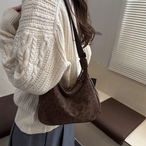 Brown leopard print suede hobo bag with adjustable strap shown on a model side view
