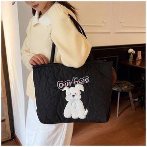 Detail der schwarzen Stepptasche mit Herzmuster und süßer Cartoon-Hund-Stickerei