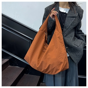 Detail van de oranje waterdichte nylon stof op een grote crossbody tas met ritsdetail