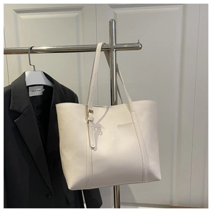 Détail du grand sac cabas beige avec bandoulière réglable et poche extérieure en U