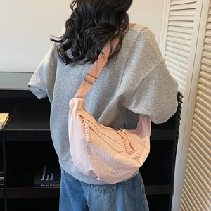 Borsa a tracolla rosa a forma di mezzaluna con spallina larga regolabile indossata