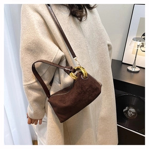 Dettaglio della borsa baguette in pelle scamosciata marrone con fibbia in metallo dorato