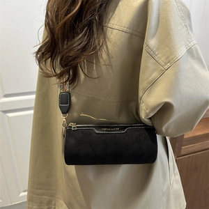 Moda borsa a cilindro nera con tracolla in tessuto colorato su un modello