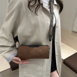 Borsa a cilindro marrone vintage con tracolla tessuta ed elegante logo stampato