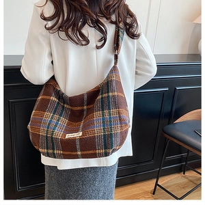 Brown plaid large capacity shoulder bag showing fit and drape on model in minimal interior