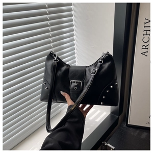 Detail of black riveted tote bag with silver studs and y2k style buckle clasp hardware
